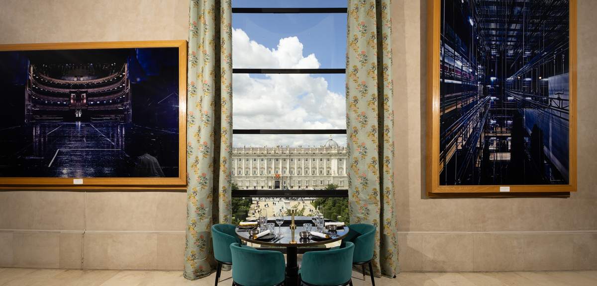Mesa de Papagena junto al ventanal, con el Palacio Real de Madrid al fondo